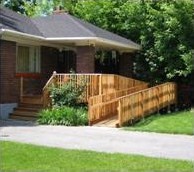 brick bungalow style-home with a wooden ramp up to the front porch