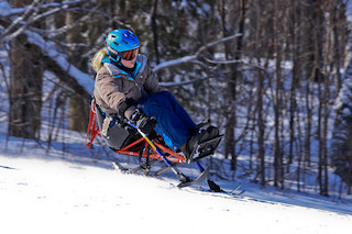 Skier using Adaptive Skiing equipment with Outriggers
